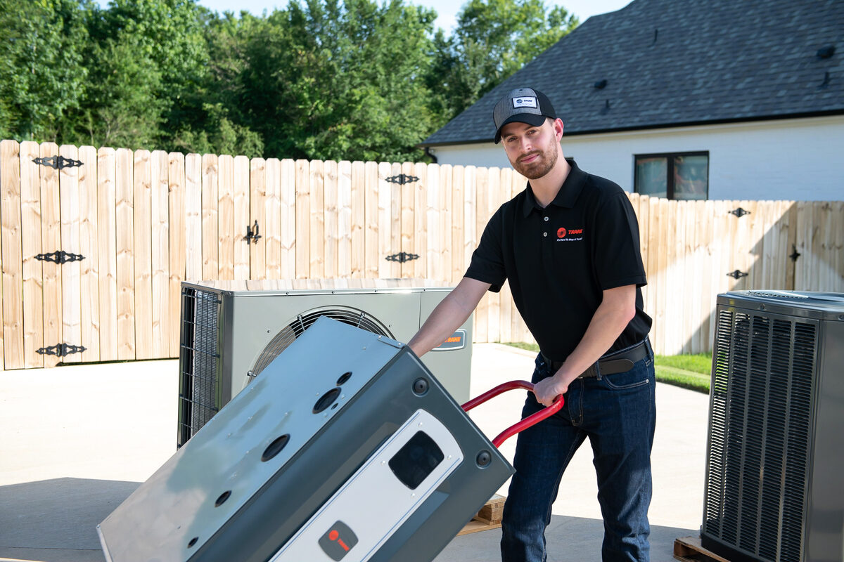 HVAC technician servicing equipment outside a home
