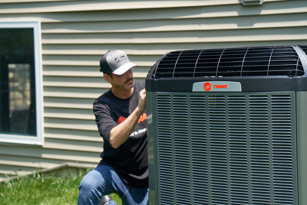 Trane specialist inspecting outdoor HVAC equipment